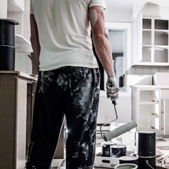 Man painting his kitchen cabinets 
