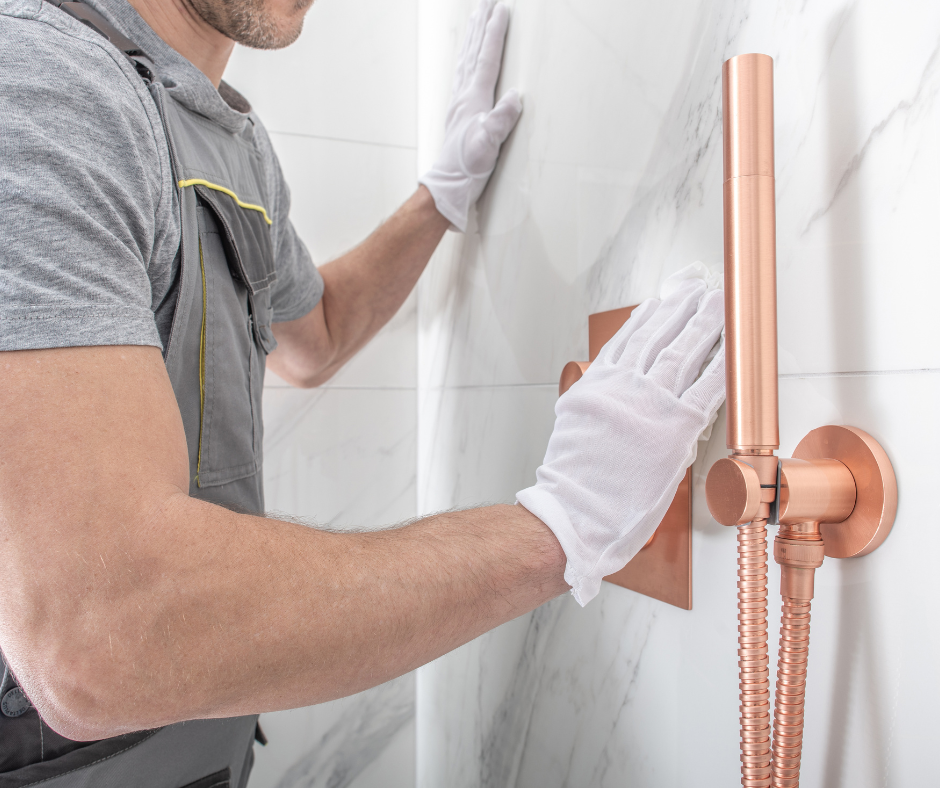 A person installing a 32 x 48 shower kit with direct to stud installation