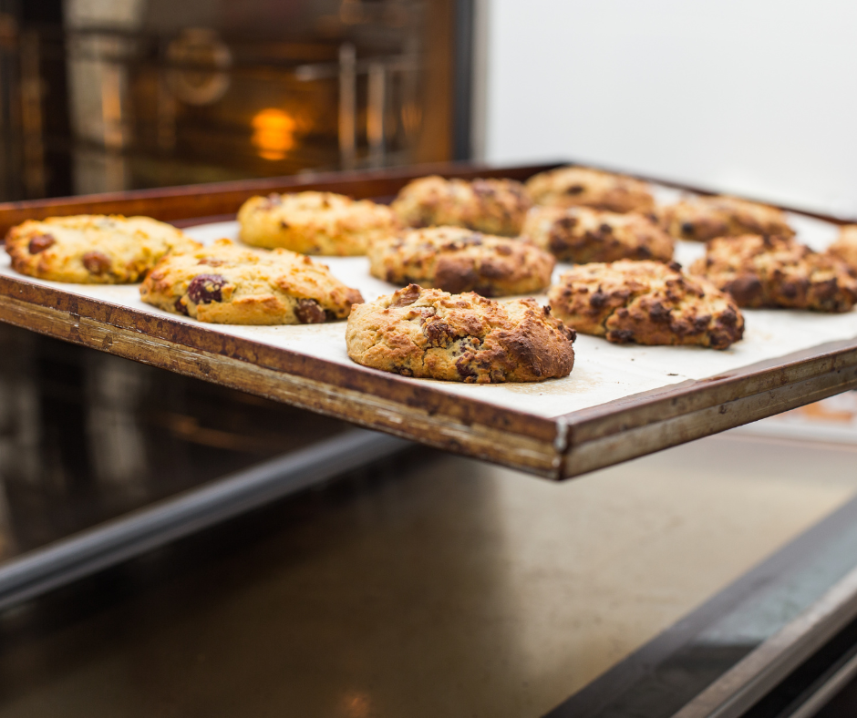 A baking pan with cookies baking in a convection oven
