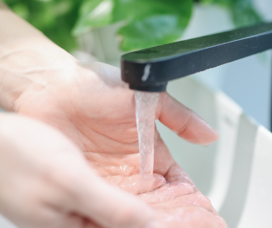 A person cleaning a faucet regularly for preventative maintenance