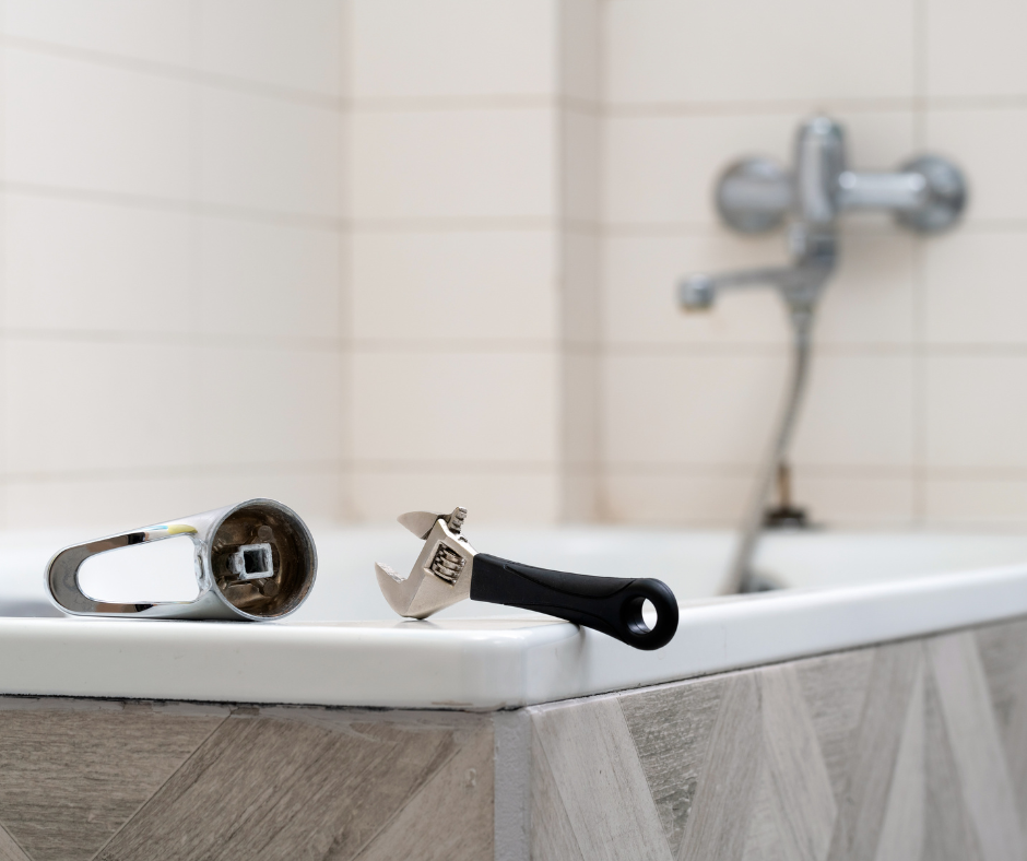 A person gathering tools and supplies for a bathtub faucet repair