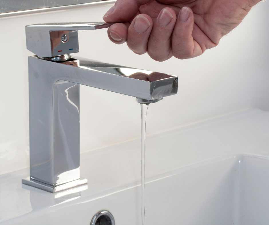 A person re-installing the handles of a Grohe bathroom faucet