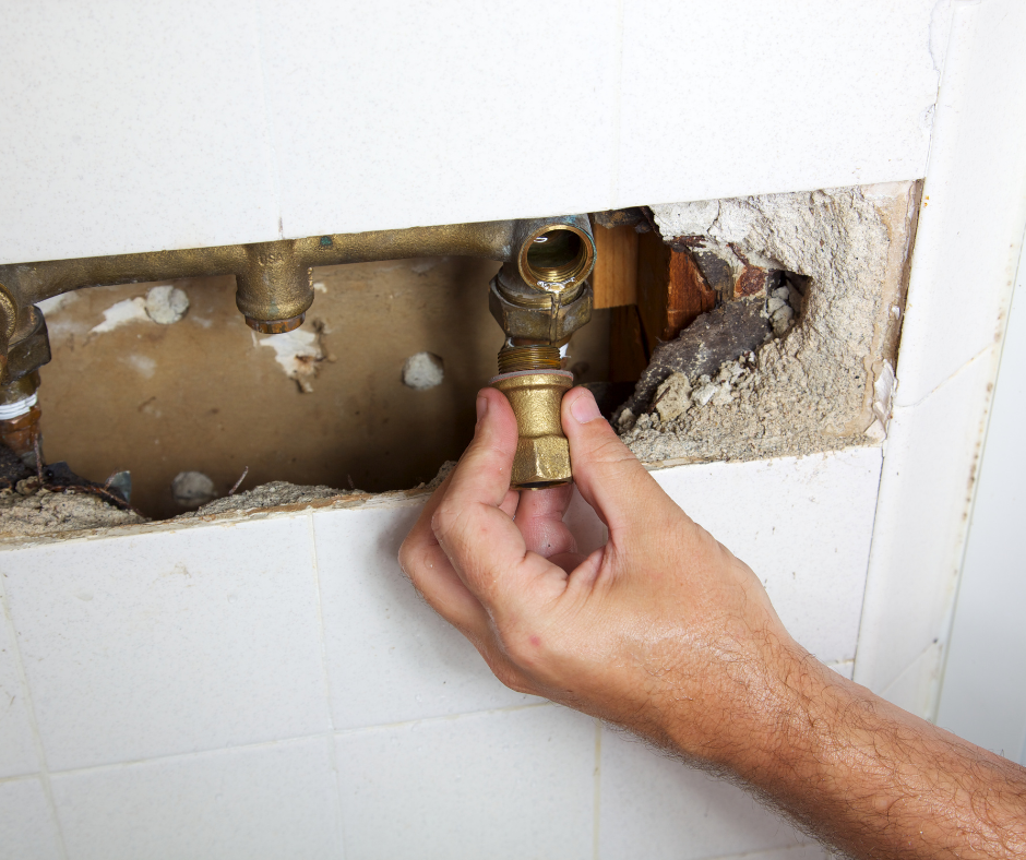 A person reassembling a shower faucet and testing for leaks