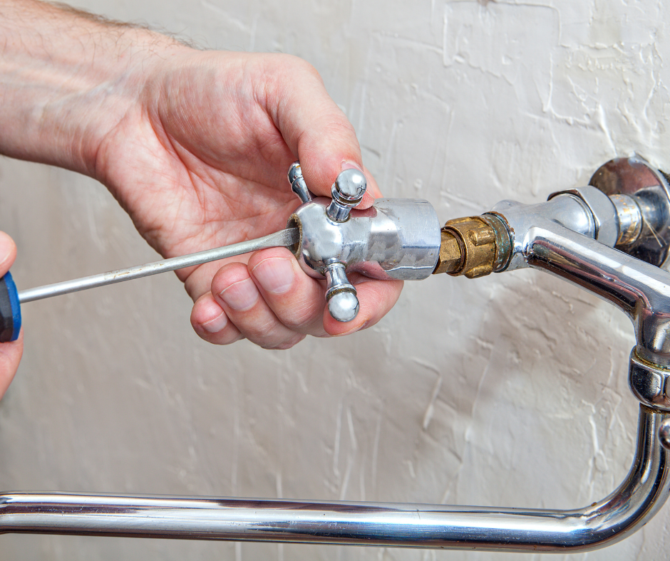 A person removing a faucet handle