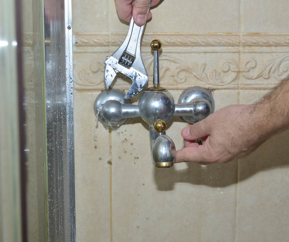 A person removing a retaining nut from a faucet