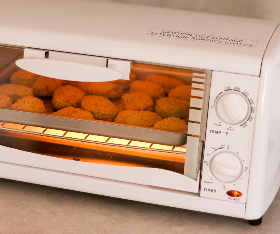 A person rotating a tray of food in a convection oven