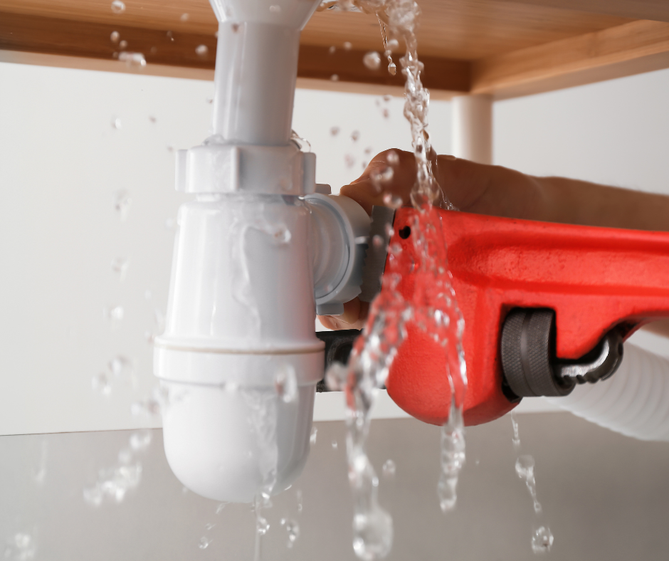 An image showing water dripping from a faucet under a sink, indicating that the faucet is leaking under the sink.